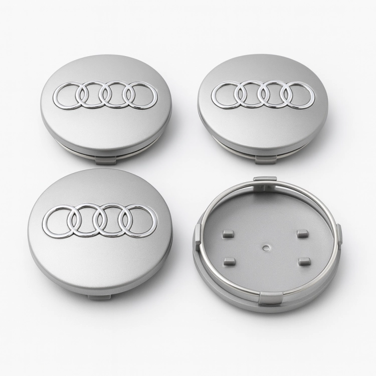 Zestaw 4 srebrnych dekielków do felg Audi 68mm ułożonych kaskadowo na jasnym tle.