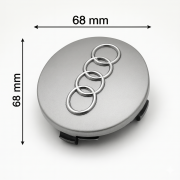 Zbliżenie na srebrny dekielek do felgi Audi 68mm z wypukłym, chromowanym logo czterech pierścieni.
